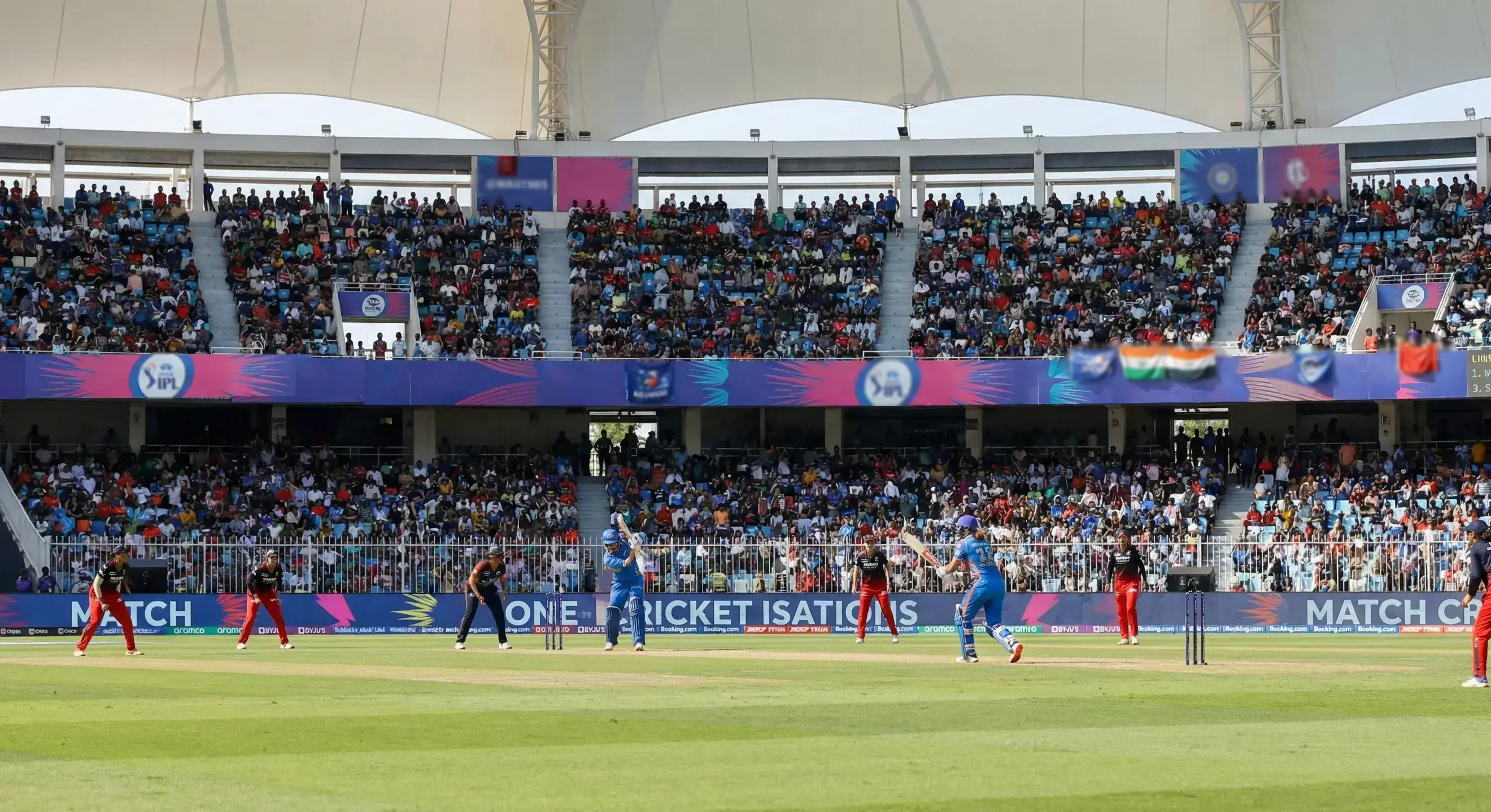 Women's cricket match in progress with players on field in stadium